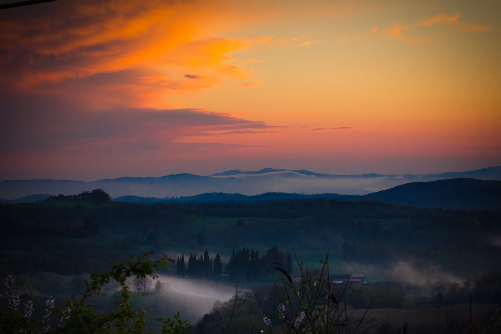 Colline toscane avvolte dalla foschia al tramonto