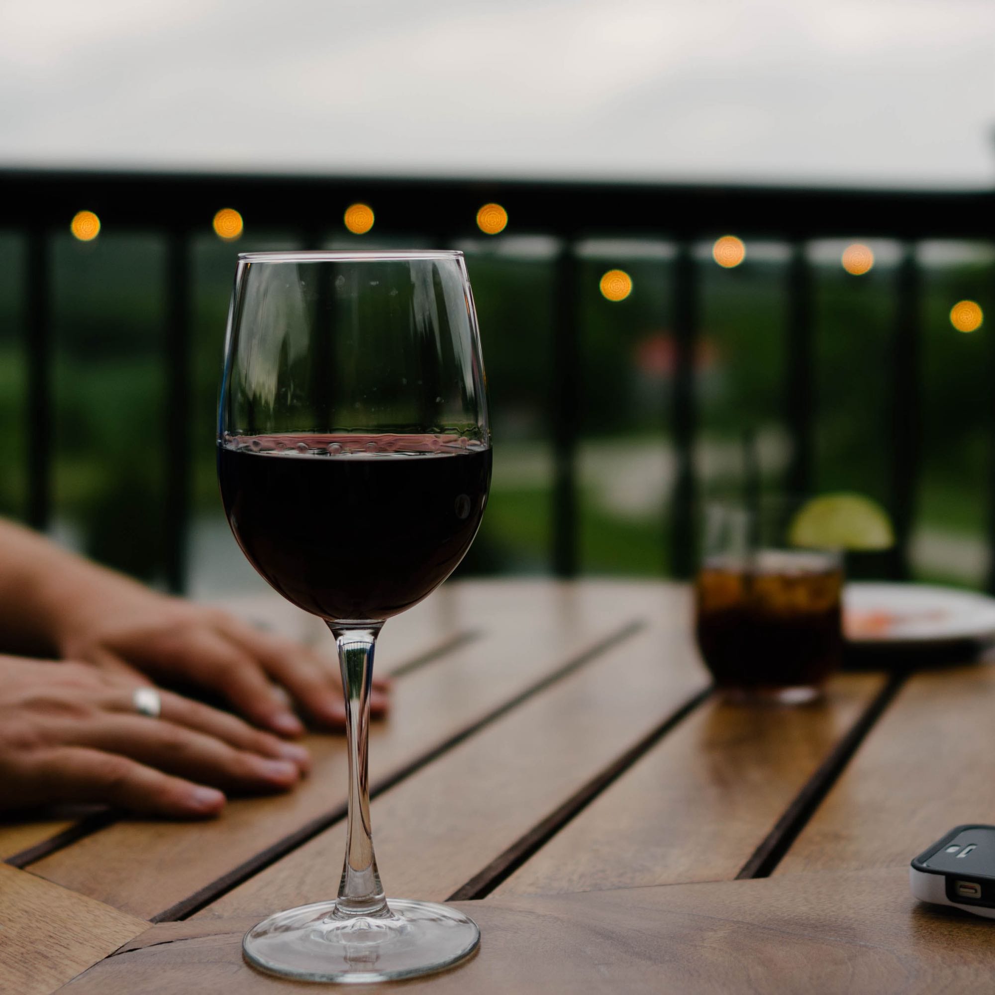 Calice di vino rosso su un tavolo all aperto, la sera